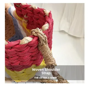 Close-up of the handcrafted woven shoulder strap on a colorful straw beach bag