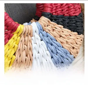 Macro shot of colorful handmade woven straw bag featuring multi-colored rainbow patterns
