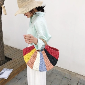 Detailed close-up of a colorful rainbow woven straw handbag for summer beach vacations