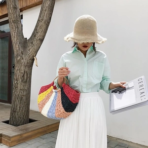 Close-up of rainbow striped straw tote bag featuring handcrafted woven texture and rope handles