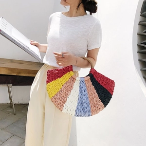 Detail of colorful woven straw tote bag with rainbow stripes and sturdy braided handles