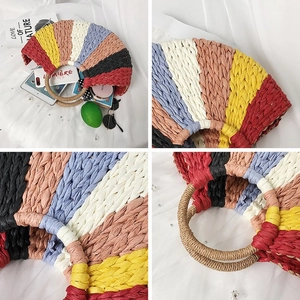 Detailed view of colorful woven straw bag with circular handles and rainbow stripes