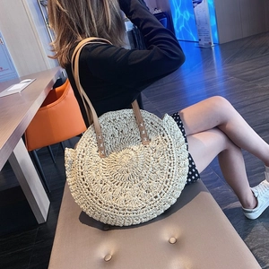 Close-up of woven straw beach bag with intricate radial patterns and leather straps
