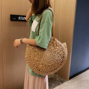 Large round straw shoulder bag with brown leather straps for summer beach vacations