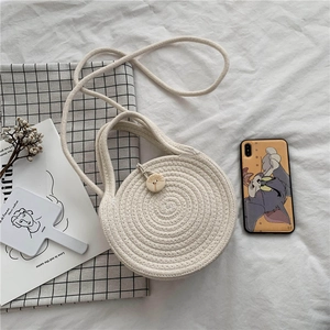 Handmade beige round woven shoulder bag with wooden button closure in a boho style