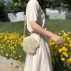 Detailed outdoor shot of a beige handmade crochet bag with hexagon floral patterns