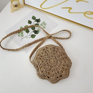 Macro shot of handmade woven straw bag with floral pattern and braided shoulder strap