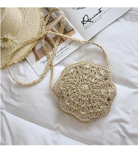 Close-up of beige handmade crochet bag with floral pattern and straw shoulder strap