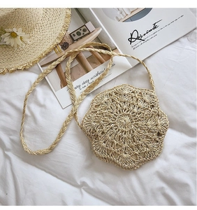 Detailed macro view of beige crochet shoulder bag with floral pattern on white linen fabric