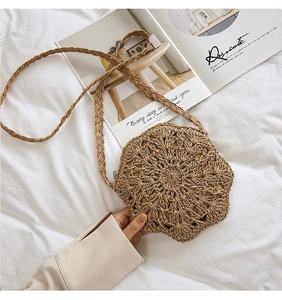 Detailed view of hand-woven round straw bag with intricate star geometric patterns