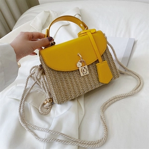 Straw crossbody bag with bright yellow leather flap and floral detail for summer style