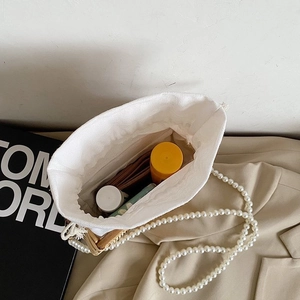 Détail du sac en paille tressée avec doublure à cordon et bandoulière en perles