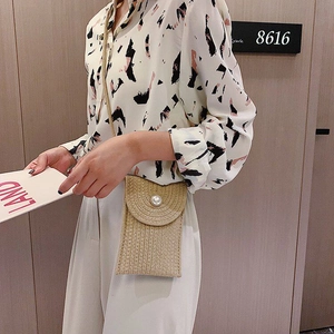 Detail of woven cotton rope crossbody bag with pearl button closure and natural texture