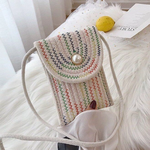 Detail of hand-woven cotton phone bag with colorful zigzag stitching and a pearl button
