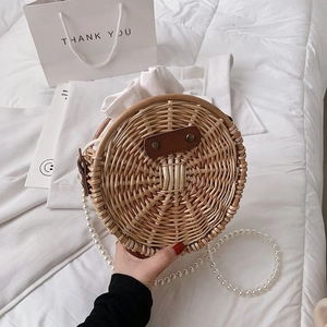 Vue détaillée du sac en paille tressée avec bandoulière élégante en perles blanches