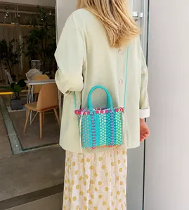 Detail van geweven crossbodytas met kleurrijke textuur en trekkoordsluiting