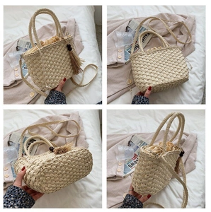 Detail of hand-woven straw bag featuring decorative wooden beads and tassel accents