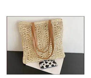 Size comparison showing a straw tote bag with a phone case to display dimensions