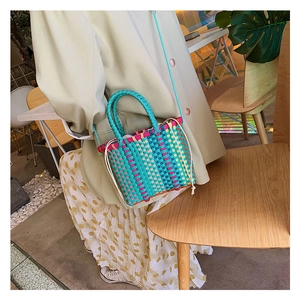 Detailweergave van een veelkleurige geweven crossbodytas in een street lifestyle-omgeving