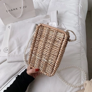 Détail du sac seau en paille tissé à la main avec bandoulière perle et doublure