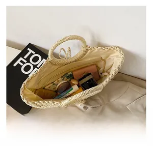 Spacious hollow straw tote bag showing large interior storage with cosmetics and a wallet