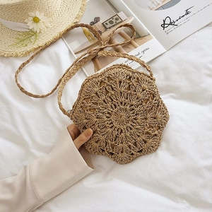 Handmade hollow-out straw bag with radial woven pattern on clean white background