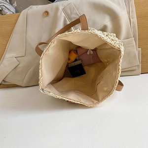 Top view of woven straw tote bag featuring spacious fabric lining and internal zipper pocket