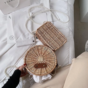 Sacs en paille avec bandoulières en perles et design rond sur tissu blanc pur