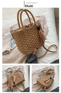 Detail of khaki straw tote bag with bohemian tassels and drawstring closure