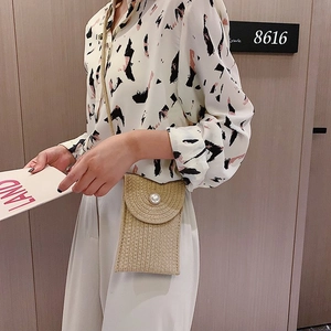 Beige woven cotton rope crossbody bag with a pearl button closure shown on a model
