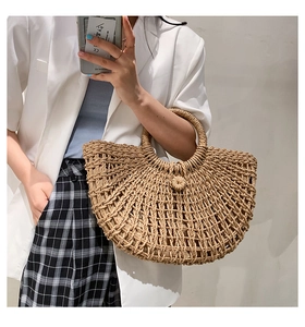 Detail of semi-circular straw handbag with large-hole weave and sturdy round handle