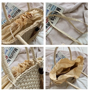 Detail view of woven straw bag showing drawstring closure and wooden bead tassels