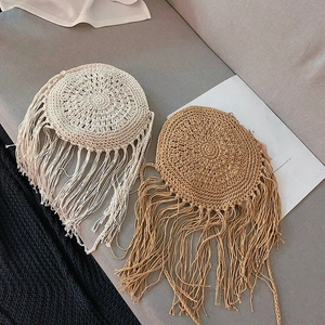 Detail of woven straw bags with long tassels in cream and brown for summer beach use