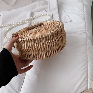 Détail du sac rond en paille tissé à la main avec poignée en cuir et bandoulière perle