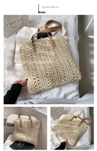 Detail of beige straw tote bag with brown leather handles and white cross stitching