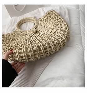 Detail of a large handmade woven straw tote bag with rounded handles and fabric lining