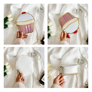Detail view of cupcake shaped crossbody bag with pink laser stripes and gold chain
