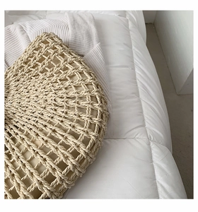 Detailed close-up of hollow-out woven pattern and beige fabric lining of a straw tote bag