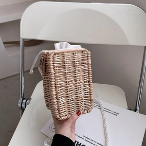 Détail du sac en rotin tressé à la main avec poignée en perles et cordon de serrage blanc