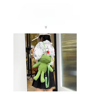 Détail d'un sac à dos peluche grenouille verte avec texture douce et sangle réglable