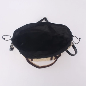 Vue de dessus d'un sac en paille avec doublure à cordon noire et bandoulière amovible