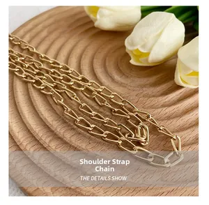 Detail of the golden metal chain strap on a wooden tray with a white tulip decoration
