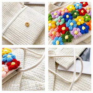 Detailed close-up of colorful crochet flowers and magnetic metal buckle on knit bag