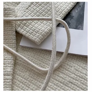 Detailed close-up of thick rope strap and woven texture on a beige crochet shoulder bag