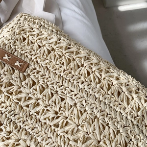 Vintage straw shoulder bag with beige woven texture and brown leather stitched details