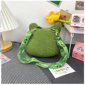 Détail du sac grenouille en peluche verte avec yeux 3D et bandoulière ajustable