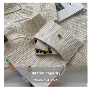 Internal capacity of knit shoulder bag showing phone and floral card holder