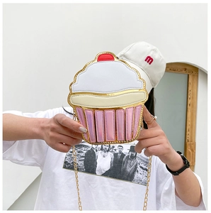 Fashionable cupcake-shaped chain crossbody bag with cherry detail held by a model