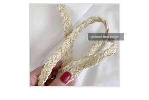 Close-up of woven cream shoulder strap detail showing textured straw braiding