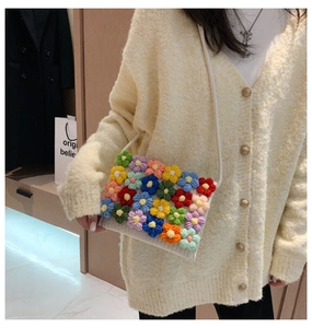 Detail of colorful 3D crochet flowers on a white hand-knitted crossbody bag for women
